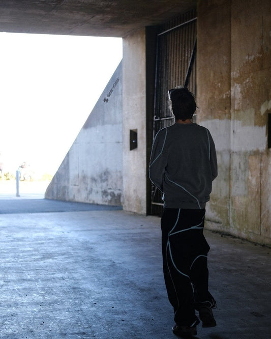 Person wearing ScervGear black baggy pants walking through an urban doorway — indie streetwear built for everyday movement