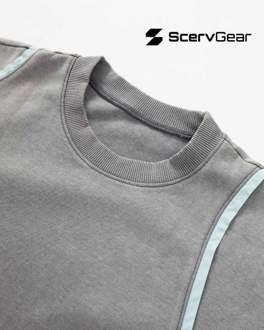 Close-up of a gray crewneck sweatshirt showing a ribbed collar, smooth cotton fabric, and a curved seam detail designed for comfort and movement.