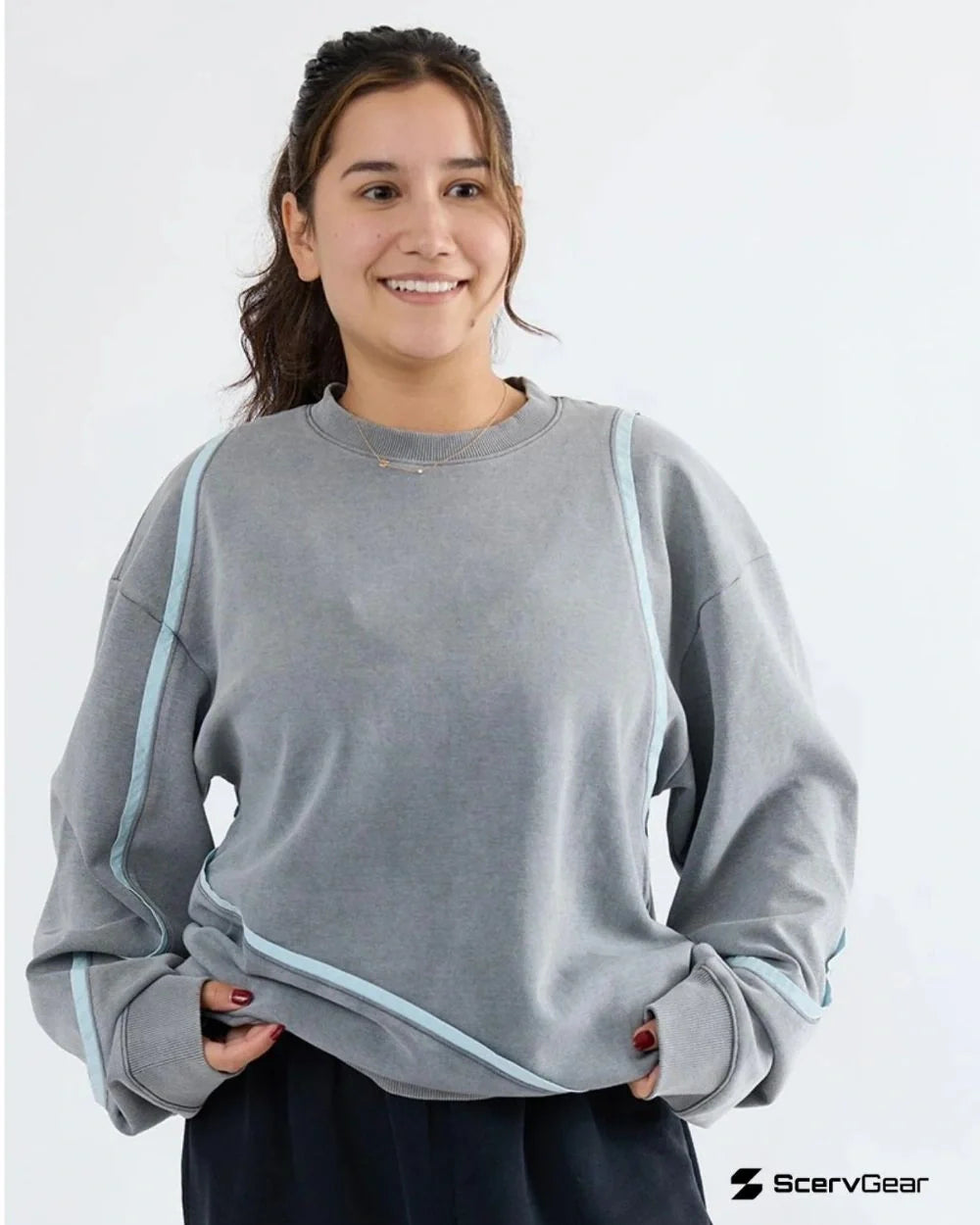 Model wearing ScervGear Swervy crewneck sweatshirt in light gray, featuring curved seam detailing and a relaxed active streetwear fit.