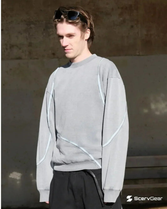ScervGear founder and designer wearing ScervGear Swervy crewneck sweatshirt in light gray, featuring curved seam detailing and a relaxed fit, styled with black pants.