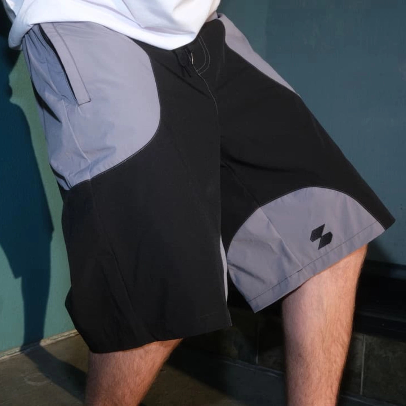 Close-up of black and gray Scerfer Baggy Boardshorts showing relaxed fit, elastic waistband, and color-block design.
