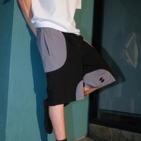Model wearing black and gray Scerfer Baggy Boardshorts with adjustable waistband and relaxed active streetwear fit.