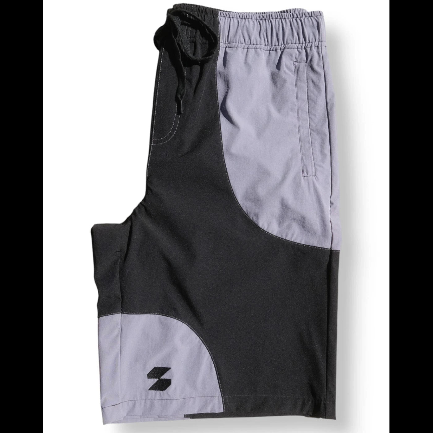 Folded black and gray Scerfer Baggy Boardshorts with elastic waistband and relaxed active streetwear fit.