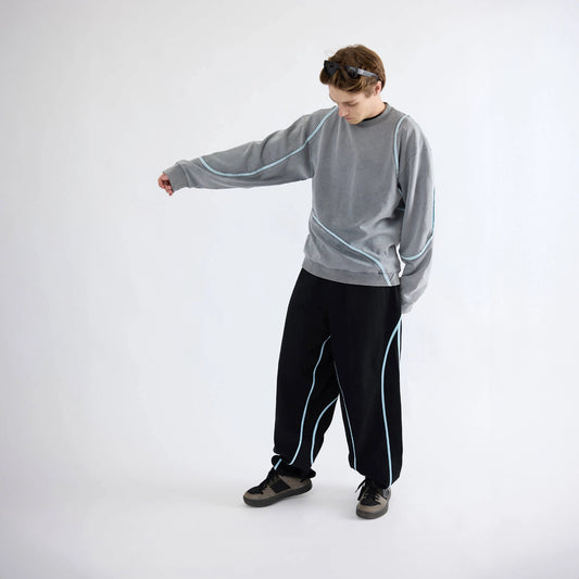 Model wearing gray Swervy Crewneck sweatshirt with relaxed fit and curved seam design for active streetwear movement.