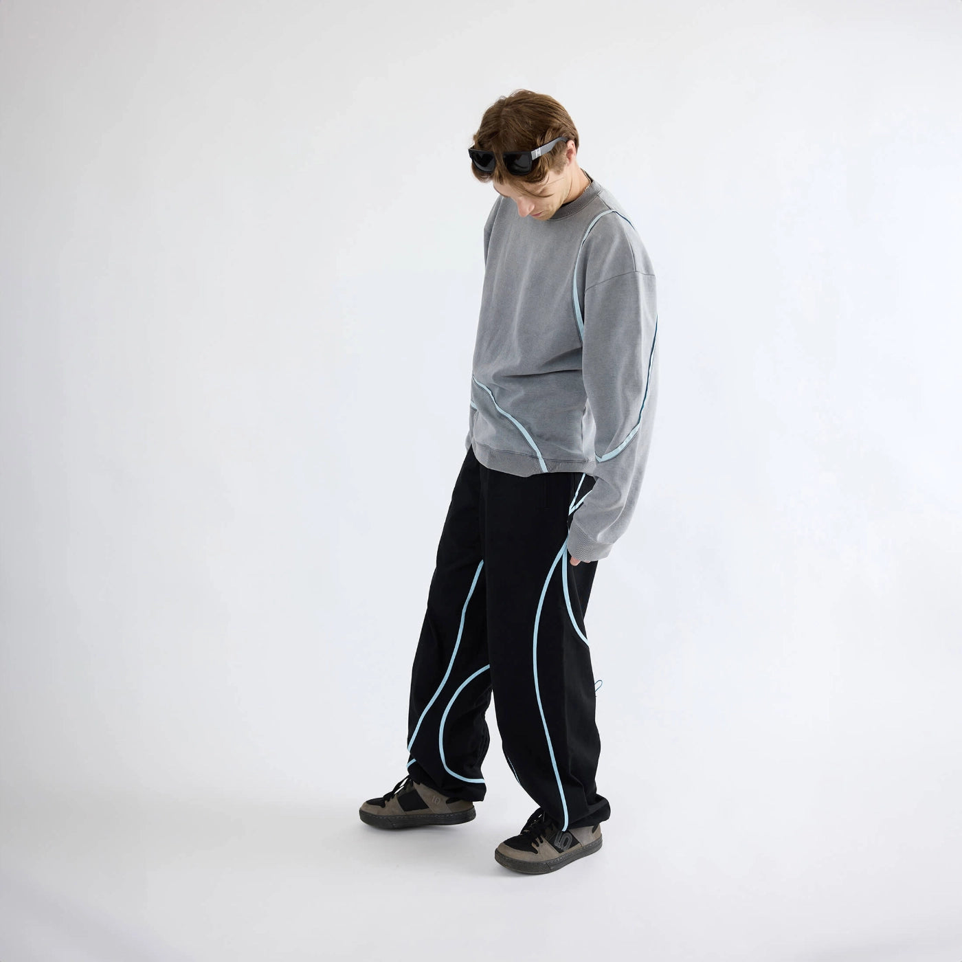 Model wearing gray Swervy Crewneck sweatshirt with relaxed fit and curved seam detailing styled for active streetwear.