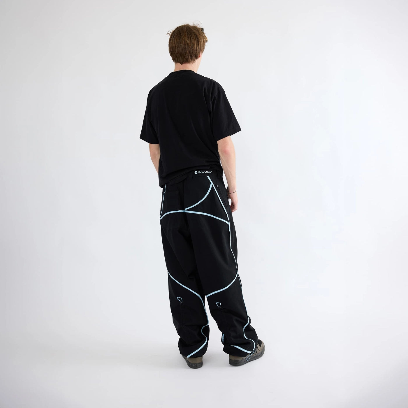 Back view of black Curvy Baggy Pants with curved seam detailing and relaxed fit designed for active streetwear movement.