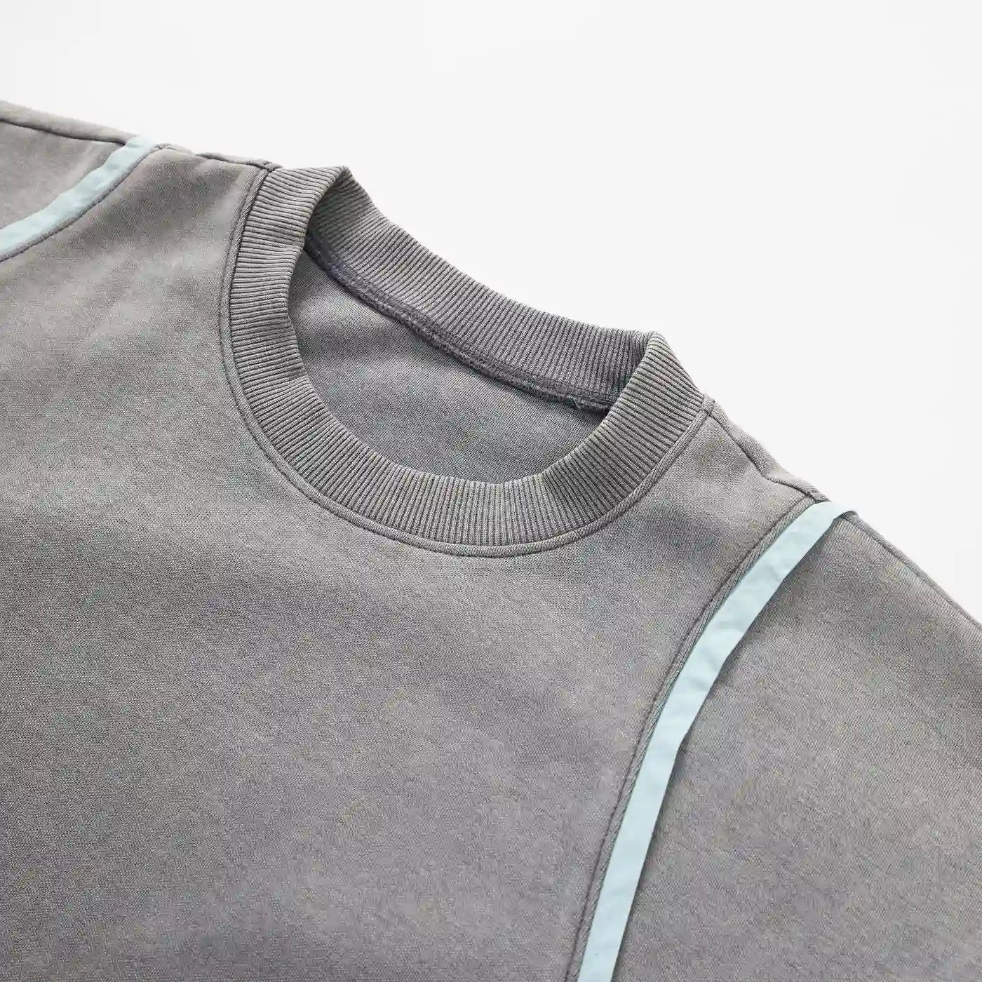 Close-up of ribbed collar and curved seam detail on gray Swervy Crewneck sweatshirt.