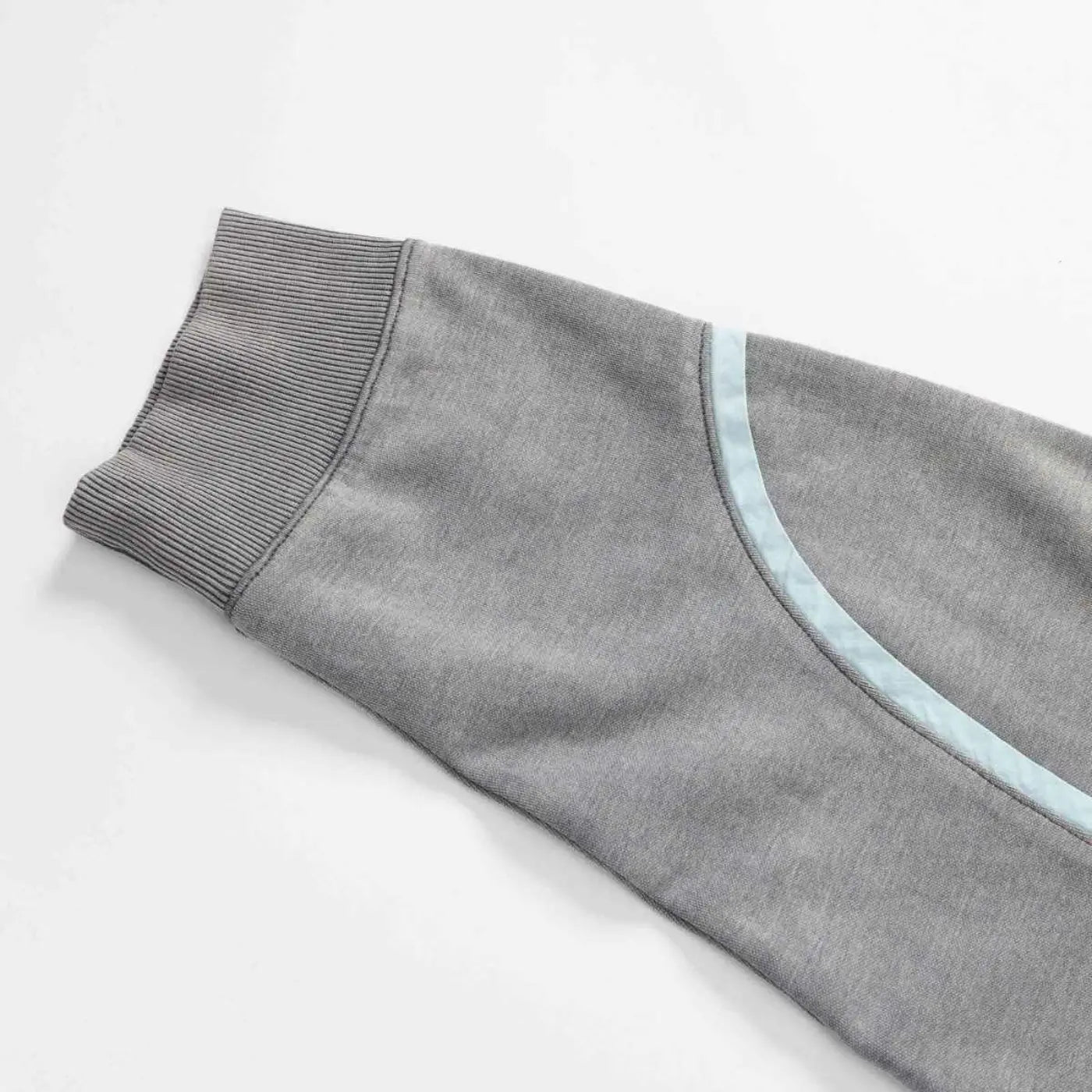 Close-up of ribbed sleeve cuff and curved seam detail on gray Swervy Crewneck sweatshirt.